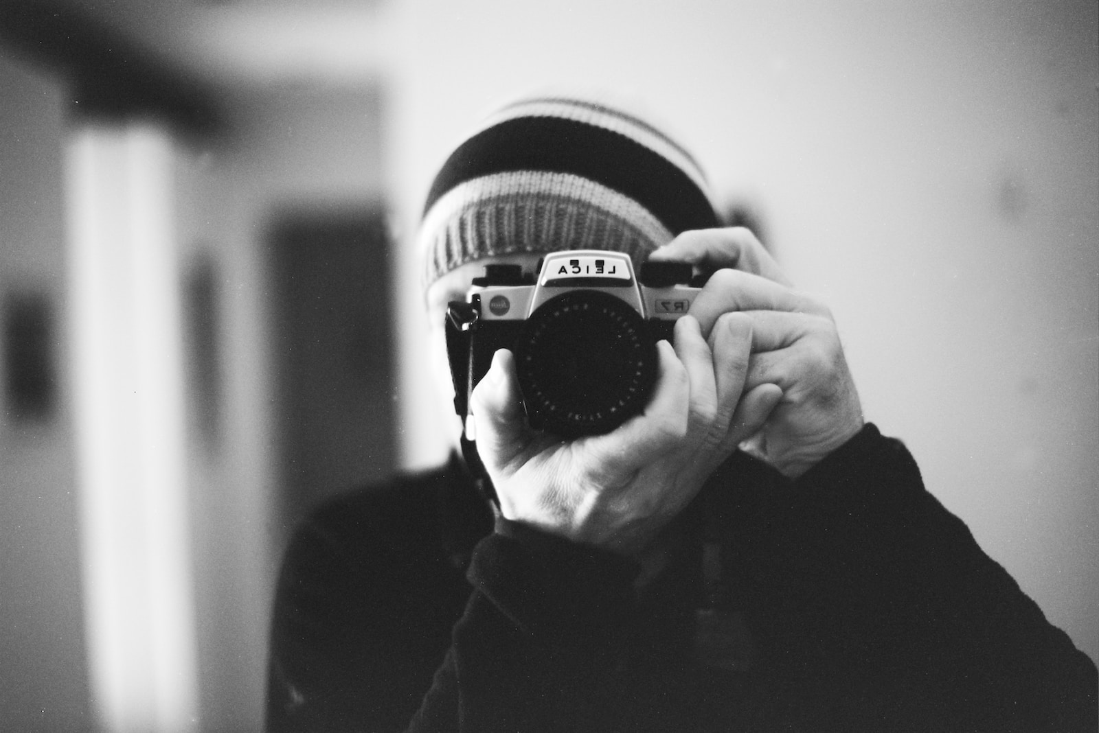 grayscale photo of person holding camera